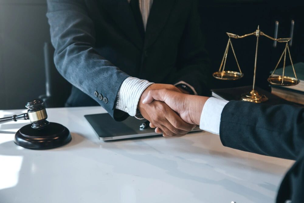Businessman shaking hands to seal a deal with his partner lawyers or attorneys discussing a contract agreement